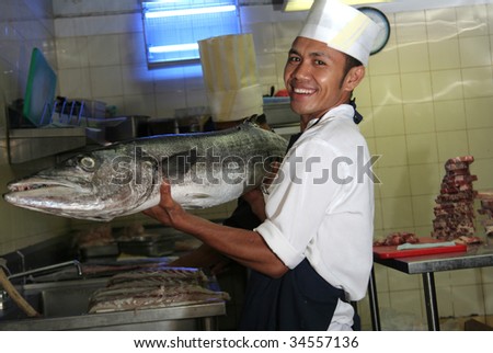 chef at butcher kitchen with fish