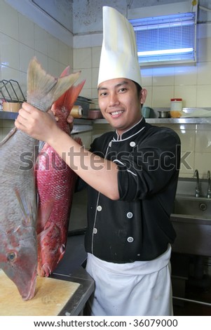 chef holding snapper fish at work
