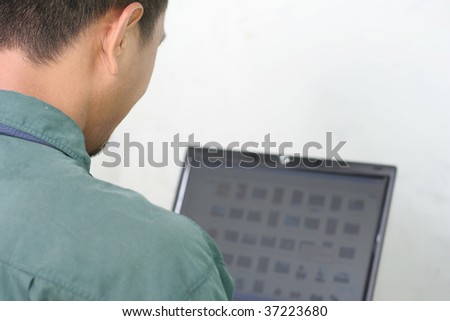 man using laptop taken from back