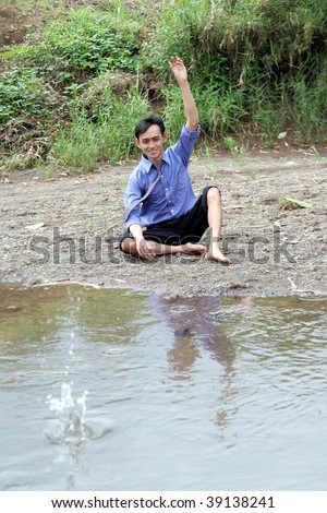 business man throwing rock on river