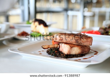 the dishes, lamb chop with other food at background