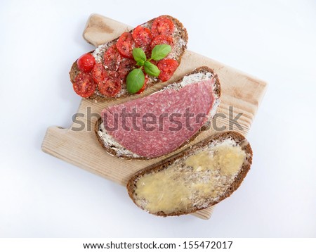 Three breakfast sandwiches on a wooden board