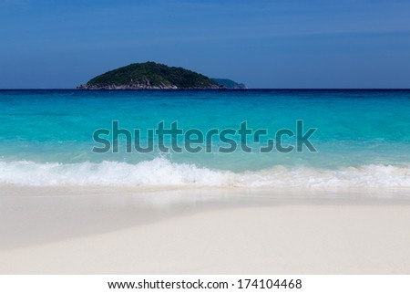 White sand beach and turquoise blue sea under a blue sky.