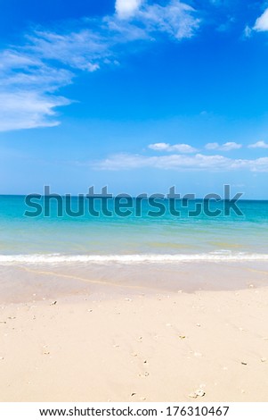 White sand beach and turquoise blue sea under a blue sky.