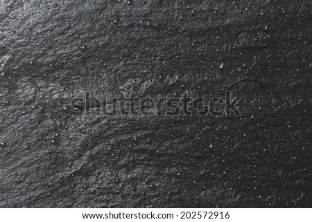 Glossy black slate background or texture.