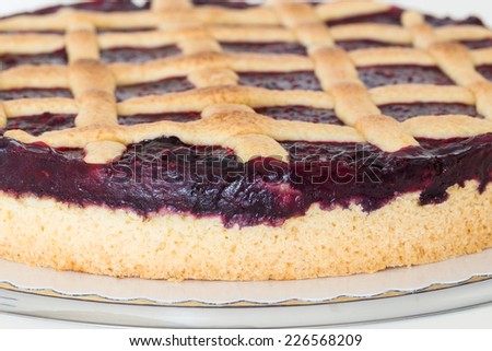 Lattice cake with forest berries against white background.