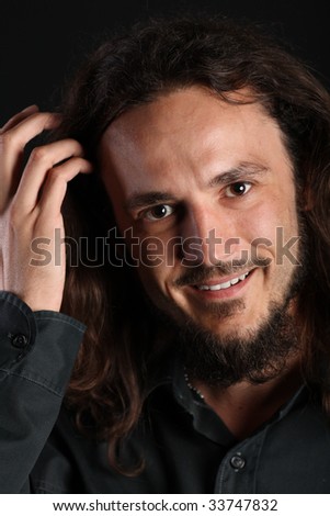 Portrait of a handsome guy with toothy smile and hand in his hair