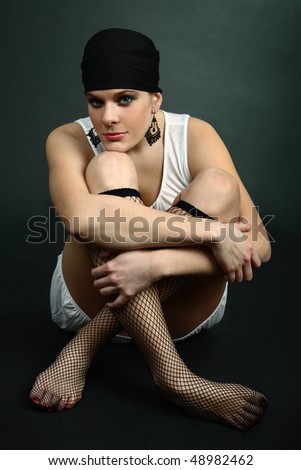 Sexy girl sitting on floor wearing fence net stockings and headscarf