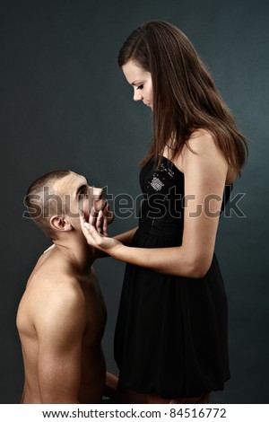 Topless young man kneels before his girlfriend