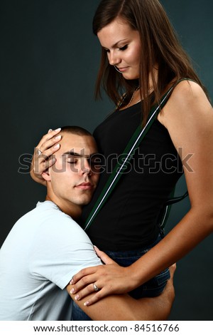 Young man kneels before his girlfriend with eyes closed