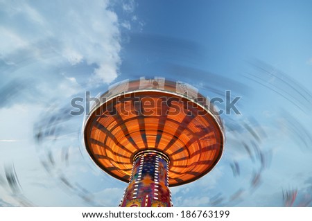 Long exposure of a spinning chain swing ride photographed at the spring beer festival in Munich, Bavaria, Germany