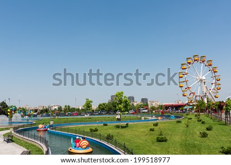BUCHAREST, ROMANIA - JUNE 08, 2014: Children On Boat Ride In Youths Public Amusement Park (Tineretului Park) On Summer Day. Created in 1965 is one of the largest fun parks in south Bucharest.