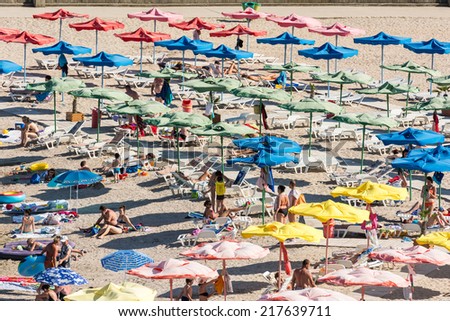 OLIMP, ROMANIA - JULY 31, 2014: Crowd Of People Relaxing Under Beach Umbrellas On Hot Summer Day.