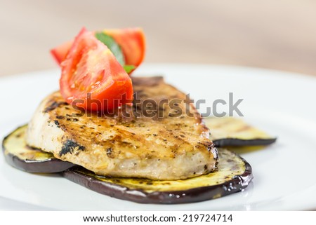 Grilled Eggplant Slice With Pork Steak And Sliced Tomatoes Close Up
