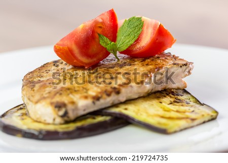 Grilled Eggplant Slice With Pork Steak And Sliced Tomatoes Close Up