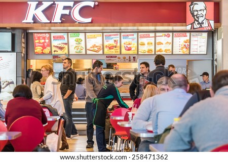 BUCHAREST, ROMANIA - MARCH 01, 2015: People Eating Unhealthy Fast-Food From Kentucky Fried Chicken Restaurant.