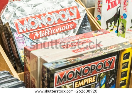 BUCHAREST, ROMANIA - MARCH 22, 2015: Monopoly Game For Sale On Library Shelf. Monopoly is a board game that originated in the United States in 1903 as a way to demonstrate the evils of land ownership