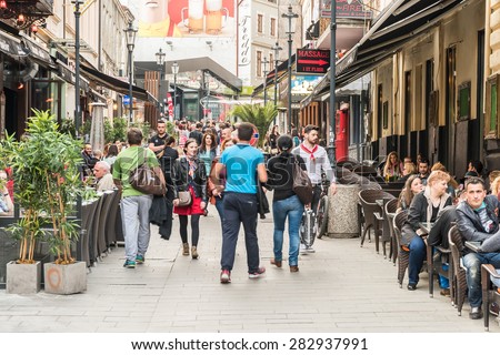 BUCHAREST, ROMANIA - MAY 31, 2015: Tourists Visiting And Having Lunch At Outdoor Restaurant Cafe Downtown Lipscani Street, one of the most busiest streets of central Bucharest.
