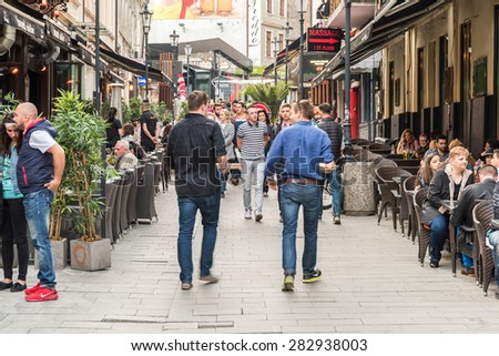 BUCHAREST, ROMANIA - MAY 31, 2015: Tourists Visiting And Having Lunch At Outdoor Restaurant Cafe Downtown Lipscani Street, one of the most busiest streets of central Bucharest.