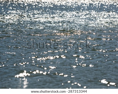 Calm Sea Water Surface In Morning Reflecting Sun Light