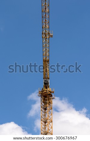 Industrial Construction Crane Against Blue Sky With Clouds