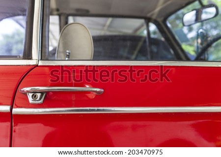 side view of old red car, door handle, keyhol, stainless bar, seat, steering wheel, rearview mirror