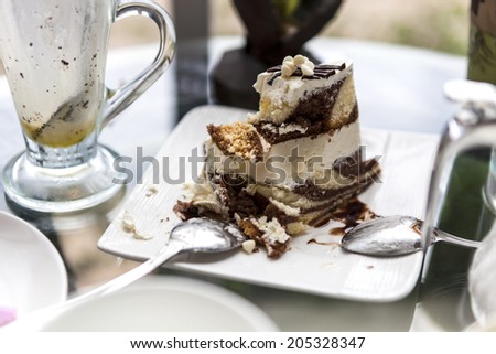 bitten piece of butter and chocolate cake on white dish, wallpaper background