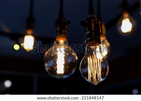 glowing bulb tungsten lamp, heated filament light, incandescent illumination on dark background