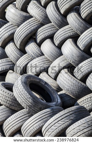 black rubber tires stacked zigzag, car wheel, garbage from vehicles, abstract art background, recycled object, reusable material, perspective view, vertical image
