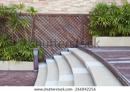 transition stair between different level wood floors and green decorative plants wall background design