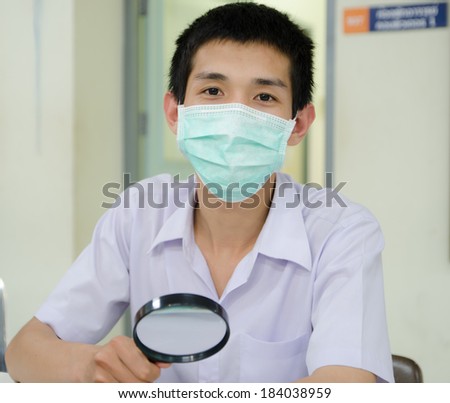 Young male Asian technician working in a laboratory sitting in his lab