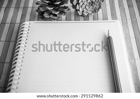 blank spiral notepad notebook with pencil on brown bamboo background