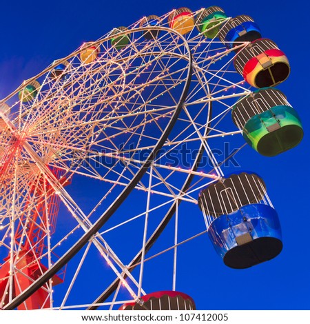 sydney luna park attraction wheel at sunset illuminated with lights in motion segment of circle