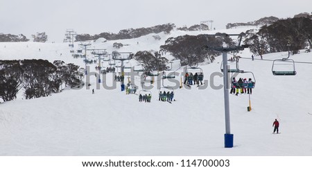 ski resort 8 chair lift up to the mountains in winter with white? snow and skiing people