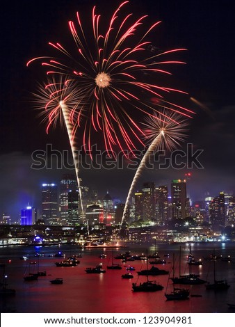 Sydney city firework New year eve illumination and reflection of lights in sydney harbour with boats fire palm tree in the sky vertical