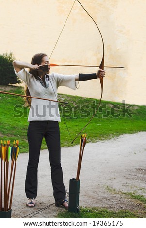 archer beauty girl plays arrow bow shooting sport stay side view position concentration