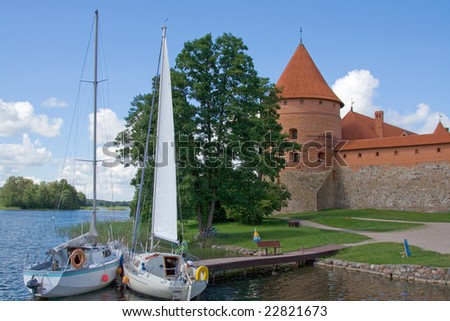 yachts parked near Mediterranean castle of red brick on lake famous tourist place lietuva trakai