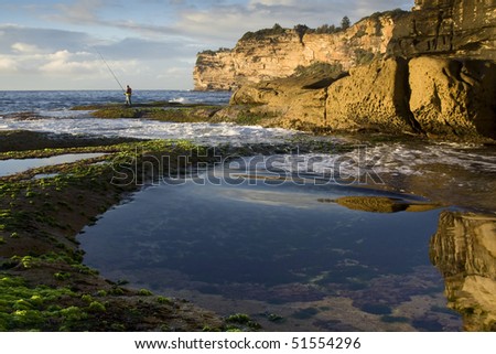 fishing fisherman rod stay salt ocean water coastline landscape cliff coming wave distorts calm reflection in pool