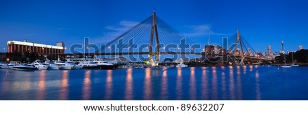 anzac bridge panoramic view at sunset with beauty lights illumination and reflection in harbour water with boats
