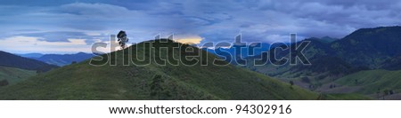 wide panoramic view on the mountain valley at sunset with green ridge of hills covered by forests, trees, grass - national park