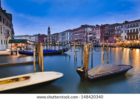 Italy venice grand canal at sunset blurred boats and gondola lights of illumination cafes and restaurants near rialto bridge