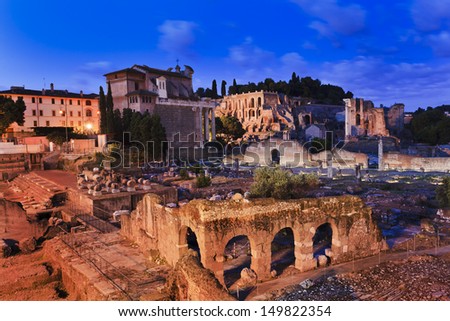italy rome ancient forum historic archaeological site of roman empire old buildings and churches illuminated at sunrise blue blurred sky