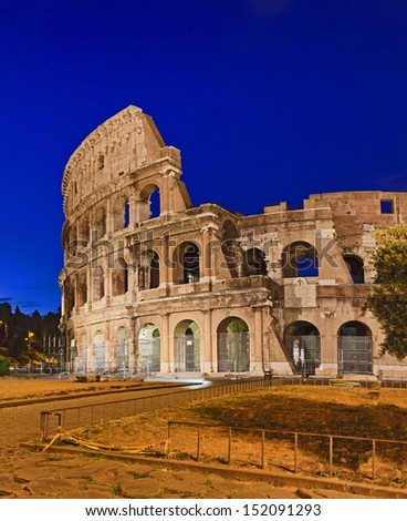 Italy Rome coliseum landmark of ancient empire stone ruins at sunrise illuminated blue sky vertical view on the wall