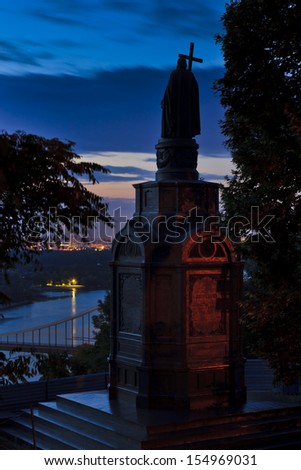 Kiev Ukraine St Vladimir monument statue at sunrise over Dnepr river banks with cross in hand facing rising sun