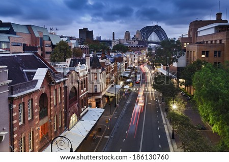 australia sydney the rocks historic district in the city view from top on george street illuminated houses and Sydney Bridge in the background at sunset