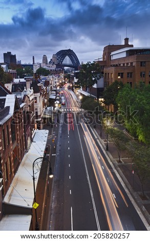 Australia Sydney The Rocks streets and rooftops from bridge at sunset blurred motor traffic with city lights and illumination