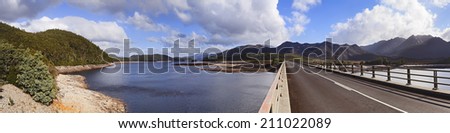australia tasmania burbery lake day time panoramic view over vehicle bridge connecting banks in remote mountain area near Queenstown