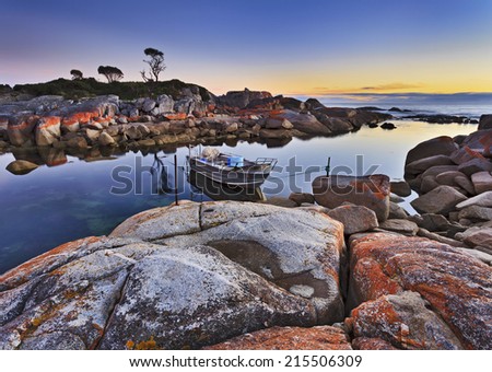 Australia Tasmania bay of fires binalong fishing boat anchored in still protected lagoon with a view on an ocean at sunrise