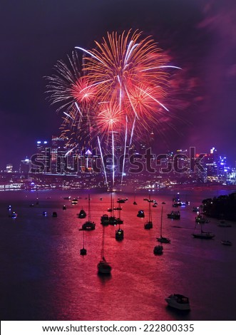 Australia Sydney New Year fireworks midnight vertical view on red balls over city CBD skyscrapers and reflection in harbour waters