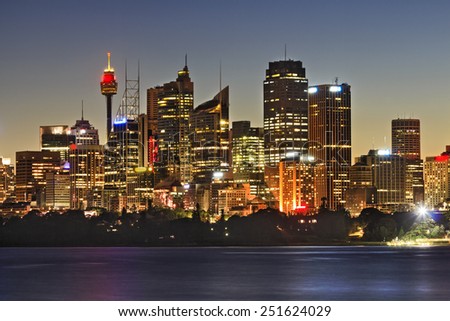 Australia SYdney city CBD skyscrapers and tower close up view over sydney harbour at sunset with full illumination